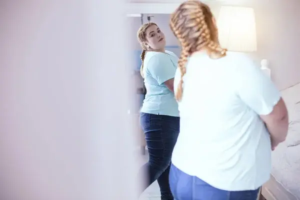 femme regardant son reflet dans le miroir, rapport difficile avec son corps