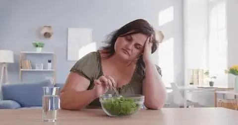 femme resignee mangeant une salade, echec du regime, envie de se sentir libre
